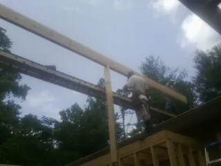 Carpenter setting a ridge beam over a new addition frame — Ice Dam Removal by Roofing Brothers in Attleboro Falls