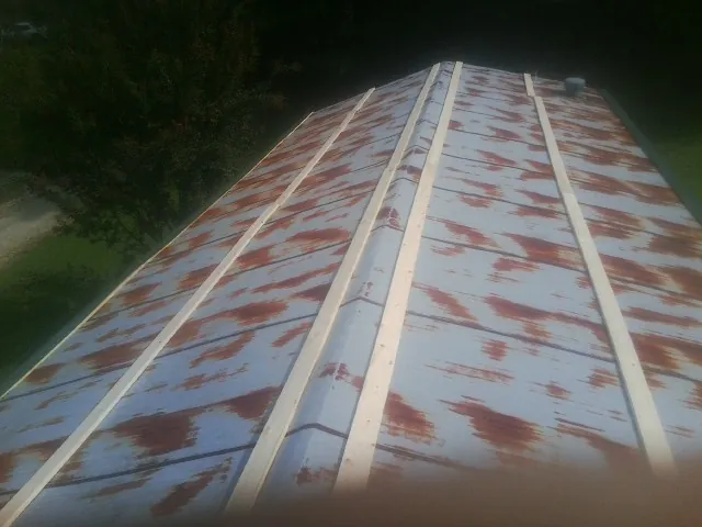 Rusted metal roof panels with new wood purlins before replacement — Storm Damage Roof Repair in Attleboro Falls by Roofing Brothers