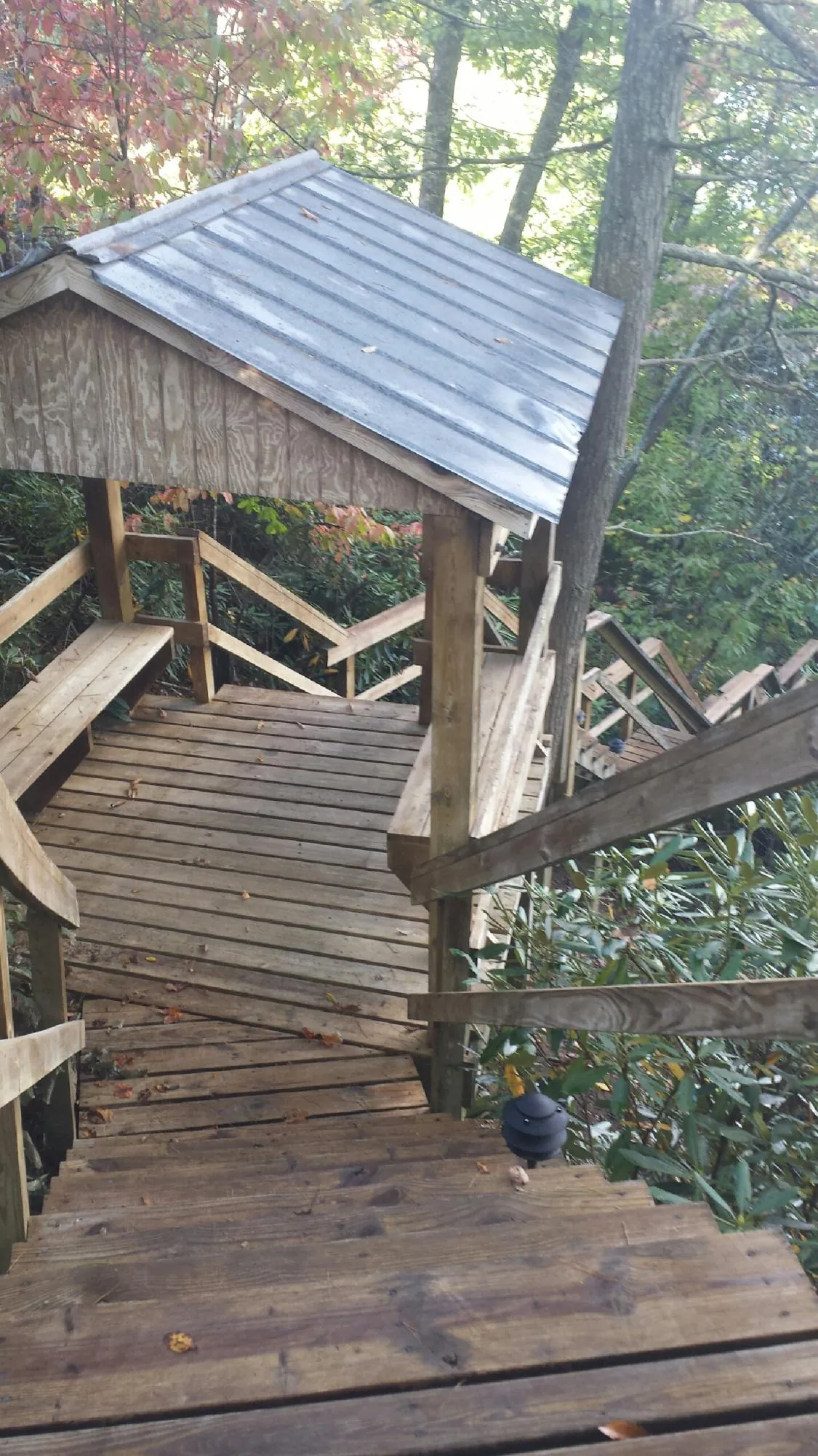 Metal roofed shelter over wooden steps on a wooded walkway — Skylight Repair & Installation work by our crew in Attleboro Falls